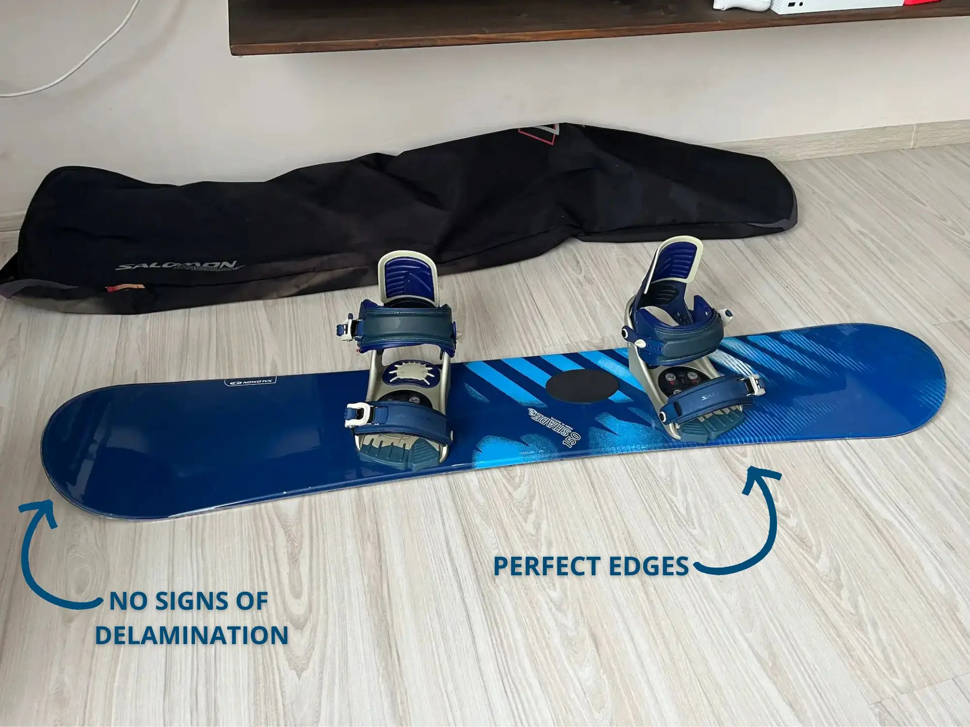 Salomon Shade 150 cm snowboard with bindings attached, lying on an indoor floor with a black Salomon board bag in the background.